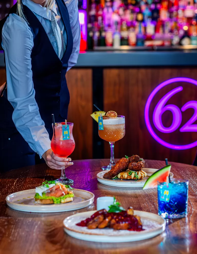 A smartly dresses waitress serving cocktails at a bottomless brunch in Barnstaple bar 62