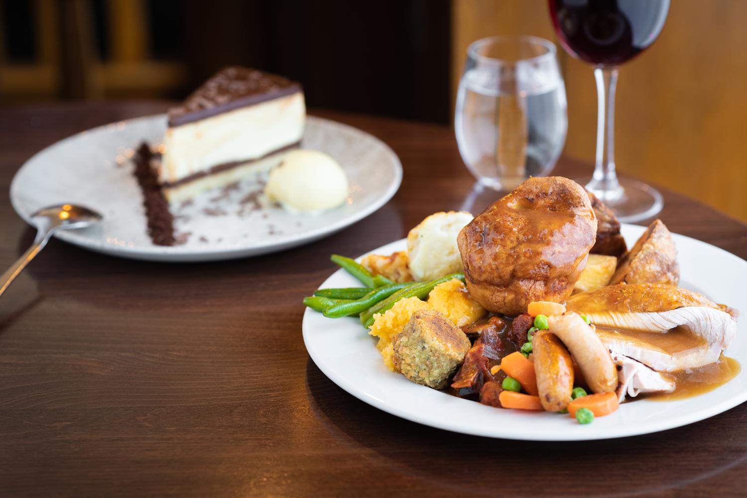 A large Sunday carvery plate containing roast turkey, Yorkshire Pudding, vegetables, potatoes and gravy 