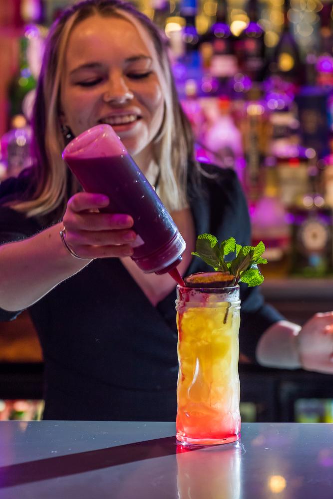 Woman making passionfruit cocktail 