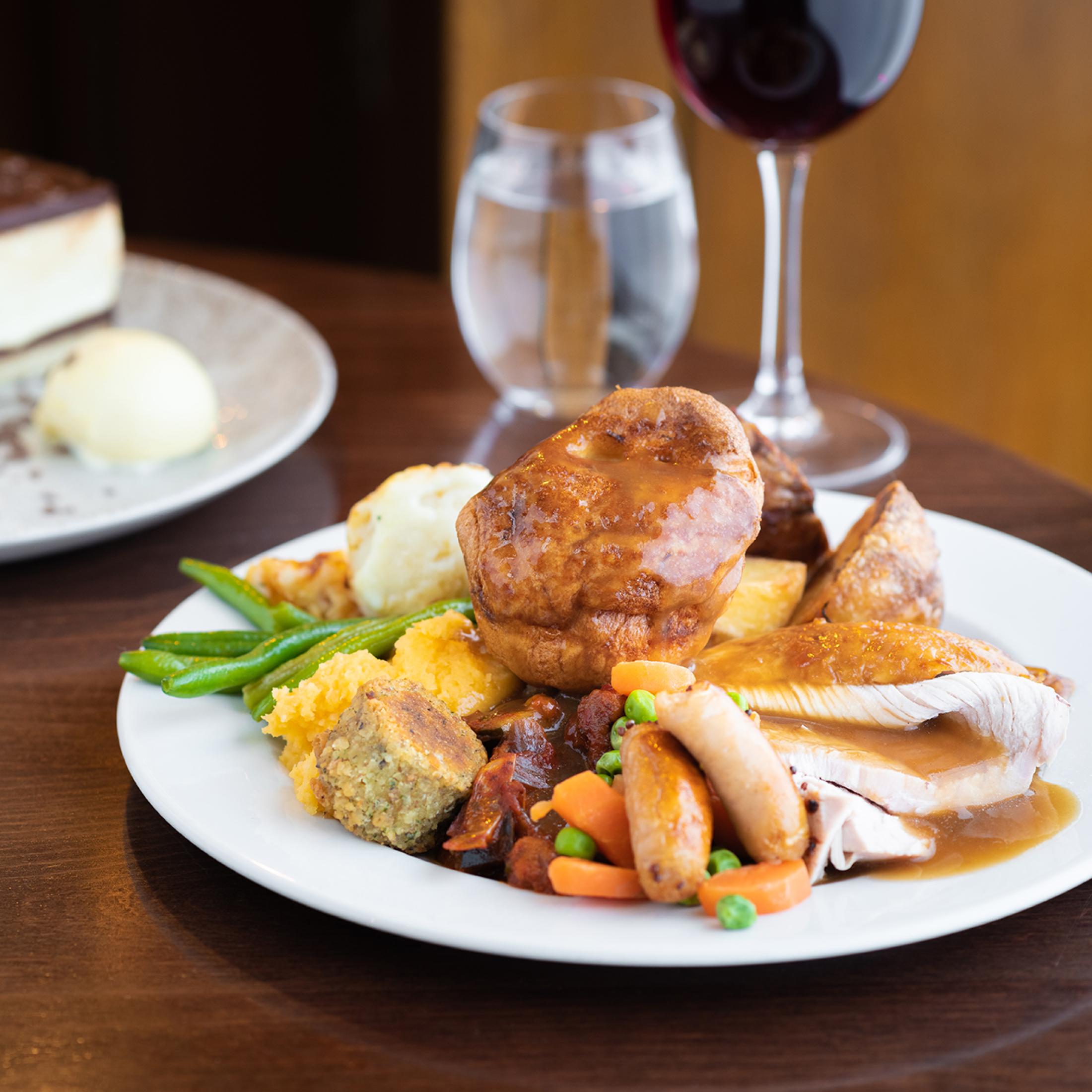 A large Sunday carvery plate containing roast turkey, Yorkshire Pudding, vegetables, potatoes and gravy 